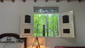 A bedroom with a wooden ceiling, a window with open shutters, a bed with white bedding, and a bedside lamp. - Finca Hotel San Miguel (Calarcá)
