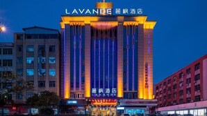 Un hotel amb un cartell destacat que diu "LAVANDE" i caràcters xinesos. Presenta un disseny arquitectònic modern amb línies verticals i una torre central.