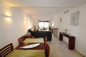 A dining area with a table set for two, a sofa in the background, and a fireplace. - La Duquesa Place in the sun (Manilva)