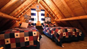 Een knus slaapkamer op zolder met twee bedden, een houten plafond en een ster decoratie.