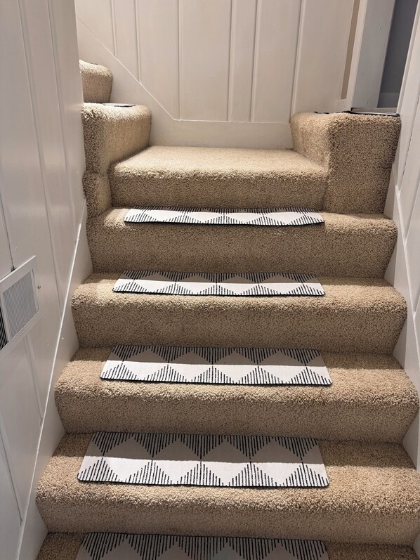 A carpeted staircase with multiple steps, each featuring a patterned runner.