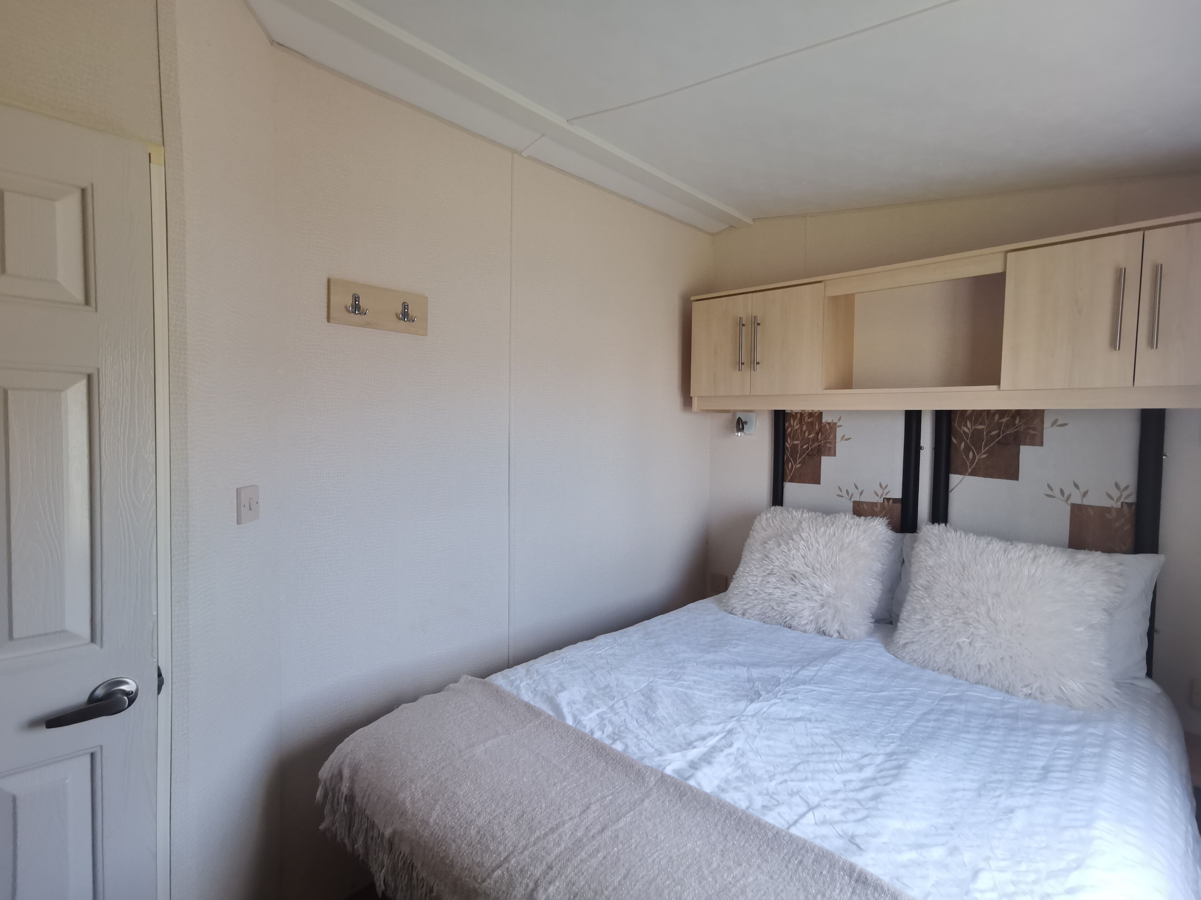Ein Schlafzimmer mit Bett, Schrank und Tür.