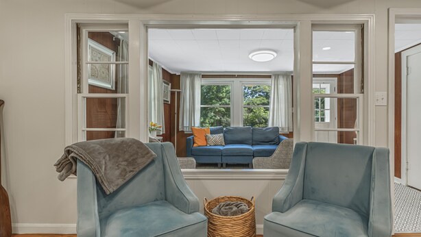 A room with two armchairs, a wicker basket, and a view of a blue sofa through a window. - Lakeside, 2-Bedroom Cottage with Fire Pit in Dickson (Dickson)