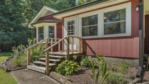 A house with a red exterior, white trim, and a wooden staircase leading to a front door. - Lakeside, 2-Bedroom Cottage with Fire Pit in Dickson (Dickson)