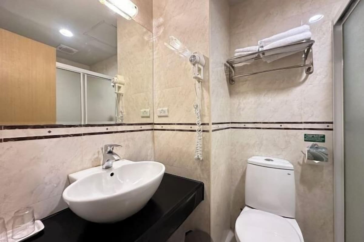 Ein Badezimmer mit Waschbecken, Toilette, Dusche und Handtuchhalter.