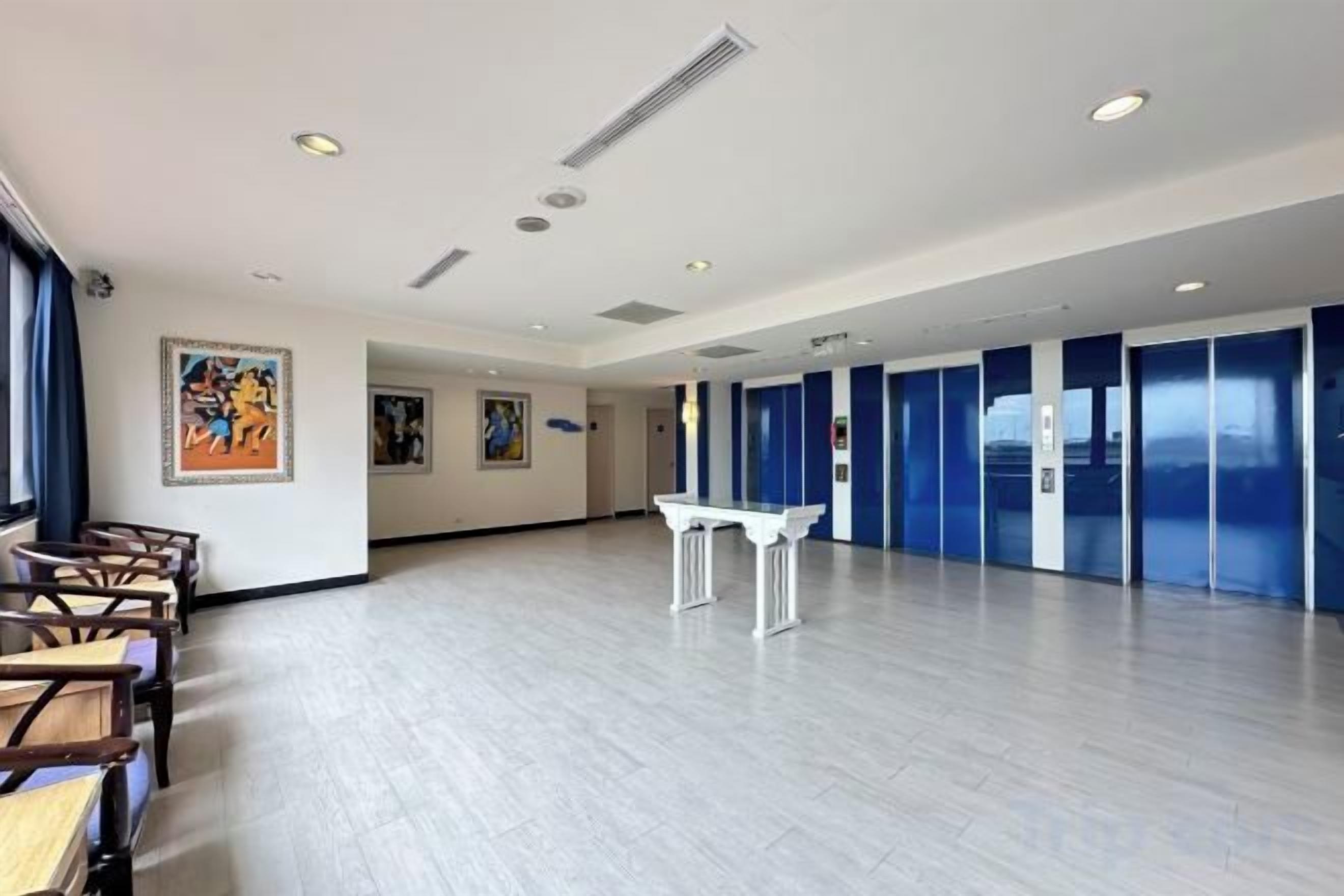 Una habitación amplia con una larga mesa y sillas, un piano y obras de arte en las paredes.