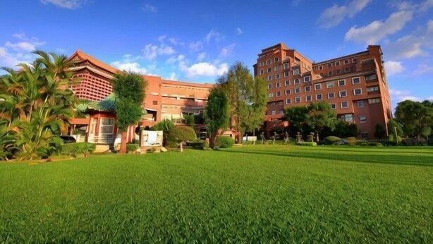 Un hotel con un amplio césped, varias construcciones y un cielo despejado.