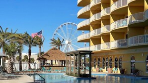 Un hotel con piscina, noria y palmera.