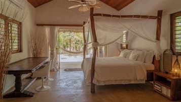 Un dormitorio amplio con una cama con dosel, un escritorio con silla y una estantería.