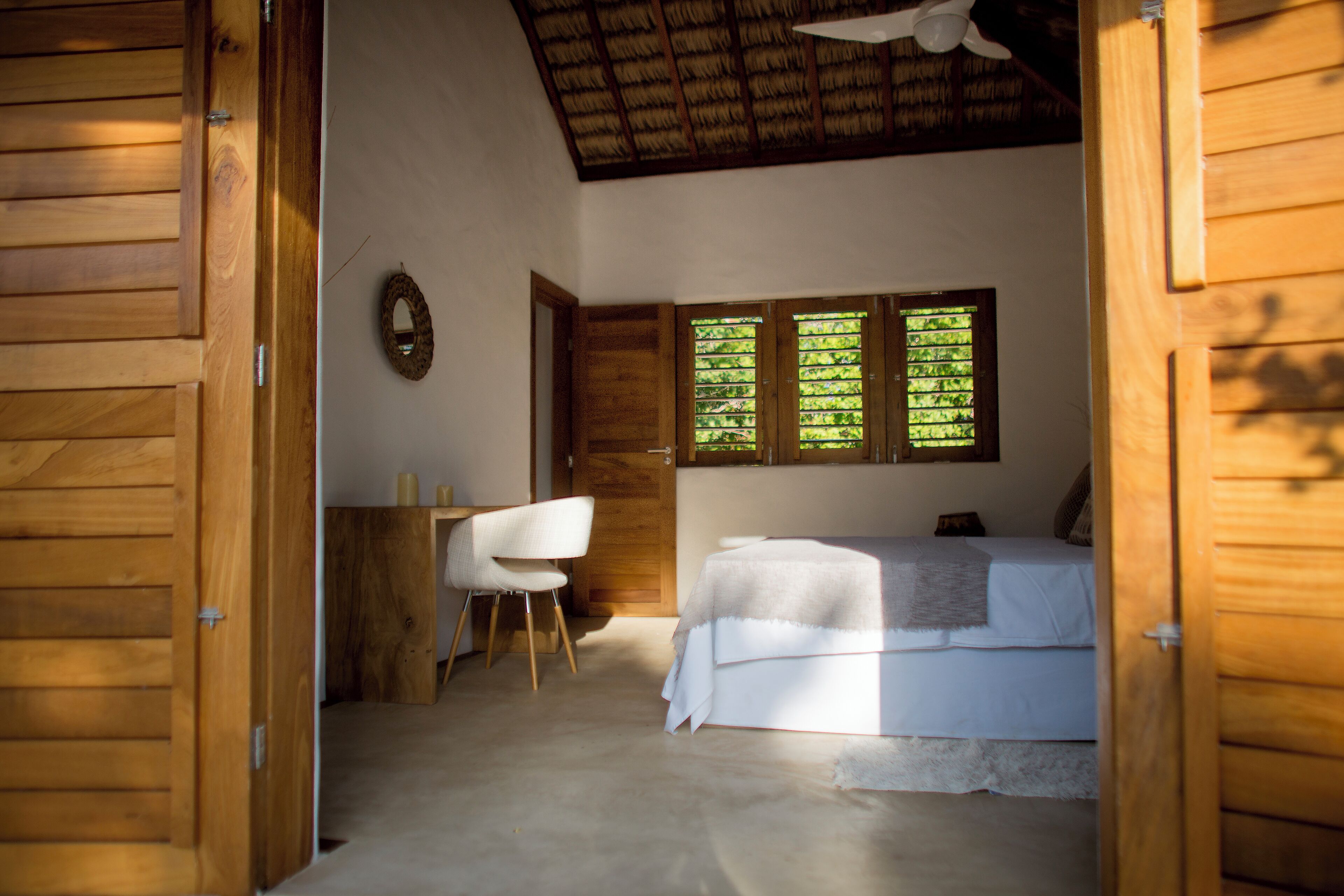 A bedroom with a bed, a desk, and a chair.