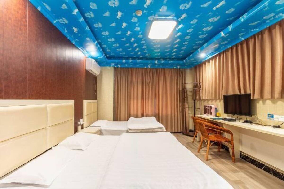 Una habitación de hotel con una cama grande, un escritorio con computadora y televisión.