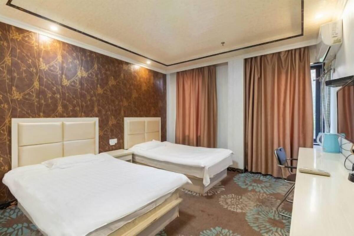 Habitación de hotel con dos camas, un escritorio y una silla.