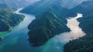 A mountainous landscape with a river winding through it. - COCOZNA Glamping (Samaná)