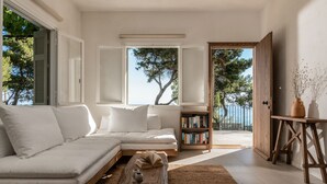 A modern living room with a white sofa, a wooden coffee table, and a bookshelf.