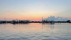 A marina with boats docked at the pier during sunset.