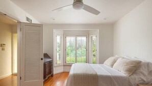 A bedroom with a bed, a dresser, and a door leading to a balcony. - Casa Dorado (San Diego)