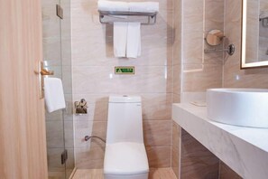 A modern bathroom with a toilet, a glass shower enclosure, a sink, and a mirror. - Vienna Hotel (Chibi Gaotiezhan) (Chibi)