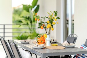 Un tavolo da pranzo con piatti, un vaso con fiori gialli e una ciotola gialla.