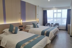 A hotel room with two beds, a desk, a chair, and a large window with curtains. - Huayue Triumph Hotel Huanghua (Huanghua)