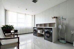 Une buanderie moderne équipée d’un lave-linge, d’un sèche-linge et d’un aspirateur.