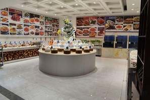 A food display area with various dishes and a central decorative piece. - Huayue Triumph Hotel Huanghua (Huanghua)