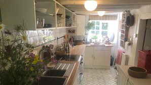 A kitchen with white cabinets, a herringbone floor, and a window providing natural light.