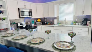 Una cocina moderna con armarios blancos, un microondas, un tostador y una cafetera.