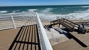 Una terraza de madera con barandilla que da al océano.