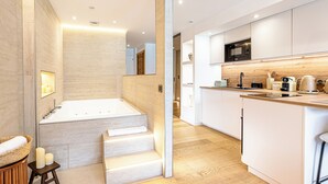 A modern kitchen with a built-in microwave, coffee maker, and kettle. - Le Rivage Alpin - vue lac et spa (Tresserve)