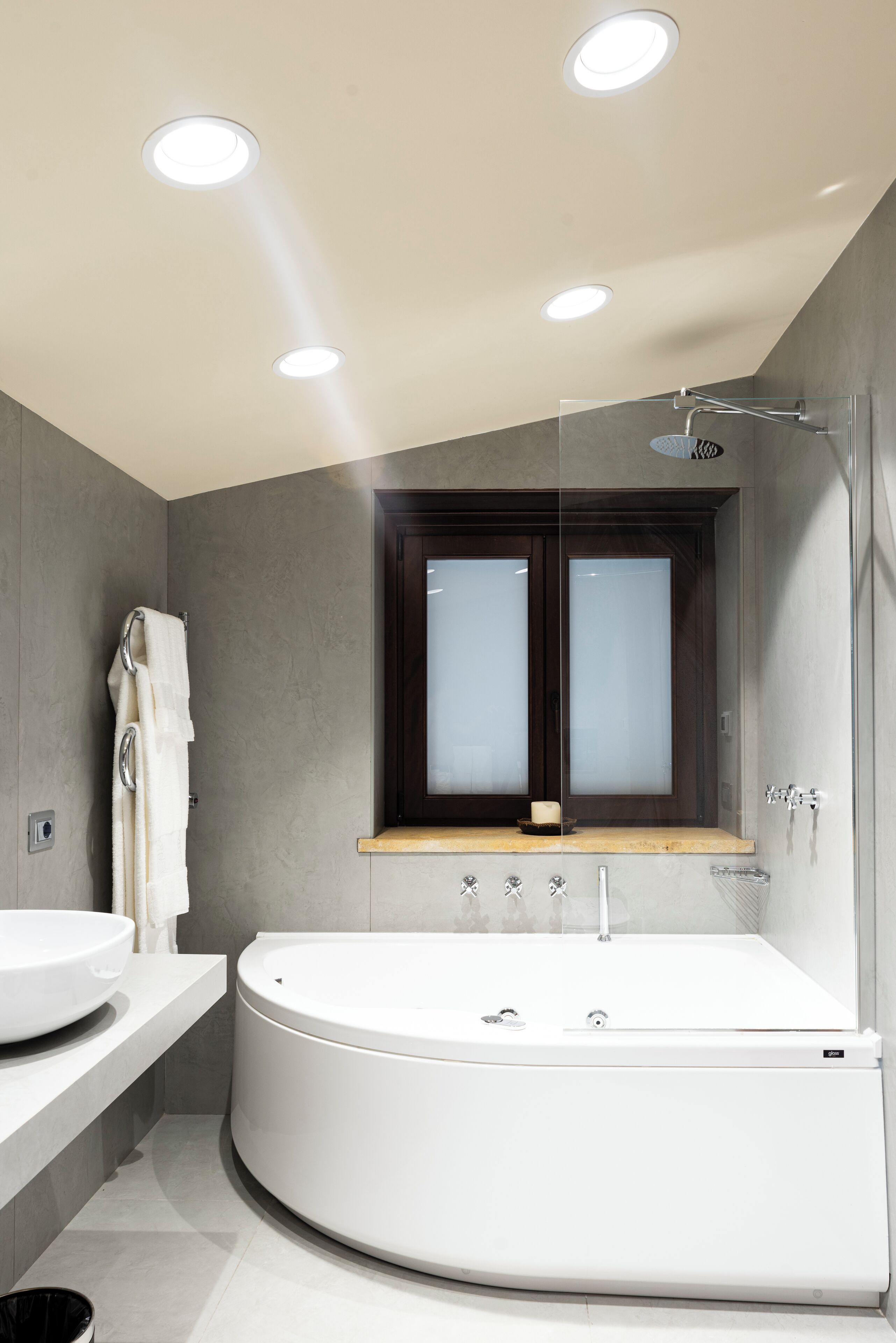 A modern bathroom with a freestanding bathtub, a vanity with a sink, and a window above the bathtub.