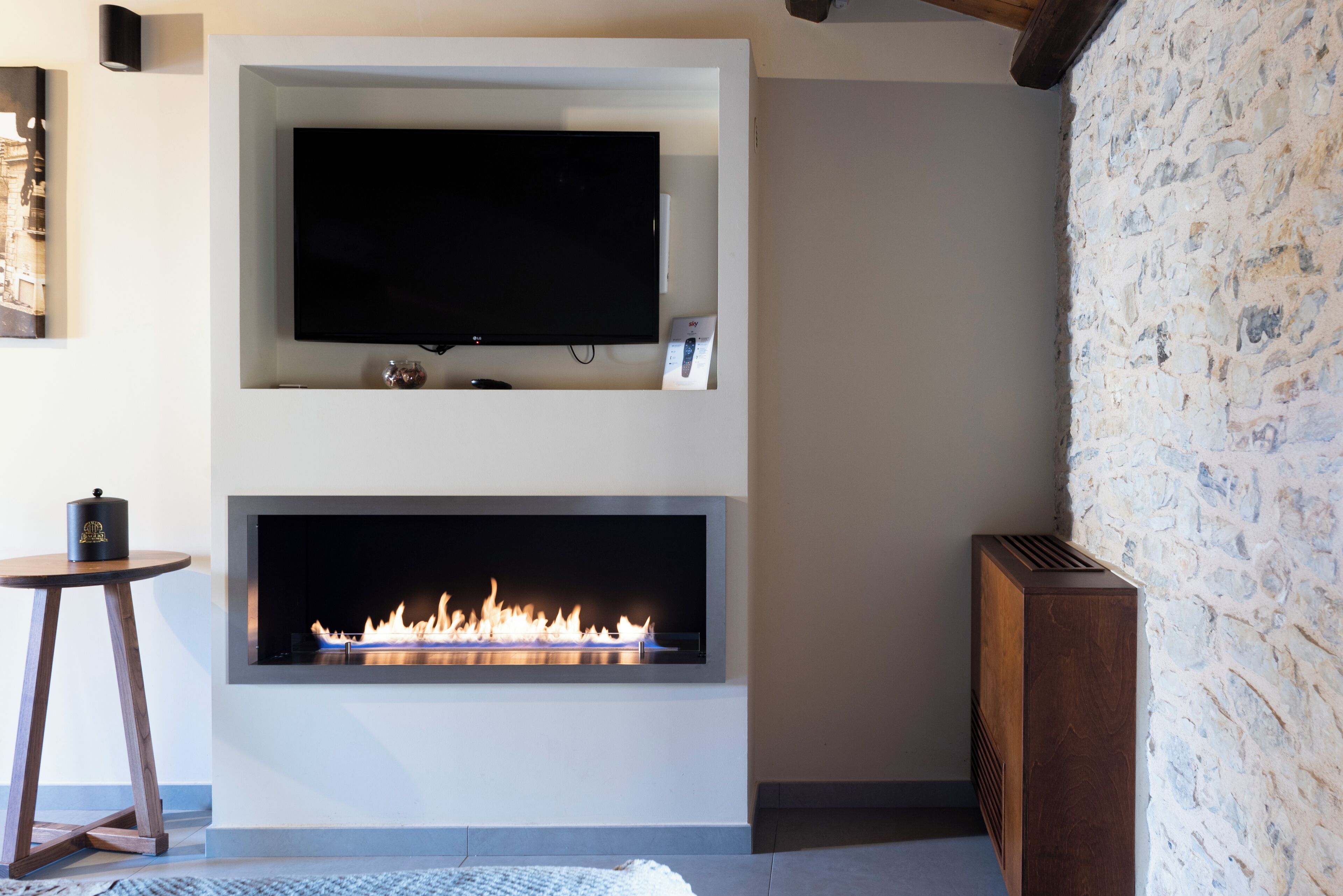 Una sala de estar moderna con un televisor de pantalla plana sobre la chimenea.