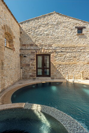 A stone building with a pool.