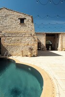 Una piscina al aire libre, sillones reclinables de piscina