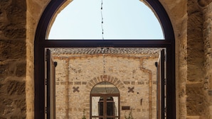 An arched doorway leading into a building with a tiled floor and stone walls. - Tenute Baglio Passofondo (Alcamo)