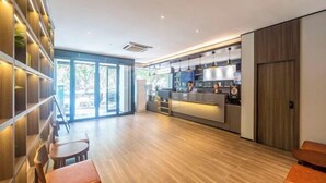 A modern interior with a kitchen area, wooden flooring, and seating arrangements. - HanTing Hotel (Zhengzhou Zijingshan Subway Station) (Zhengzhou)