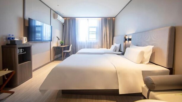 A modern hotel room with a large bed, a desk, a chair, and a television. - HanTing Hotel (Zhengzhou Zijingshan Subway Station) (Zhengzhou)