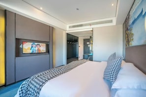 A modern hotel room with a large bed, a flat-screen TV mounted on the wall, and a painting above the bed.
