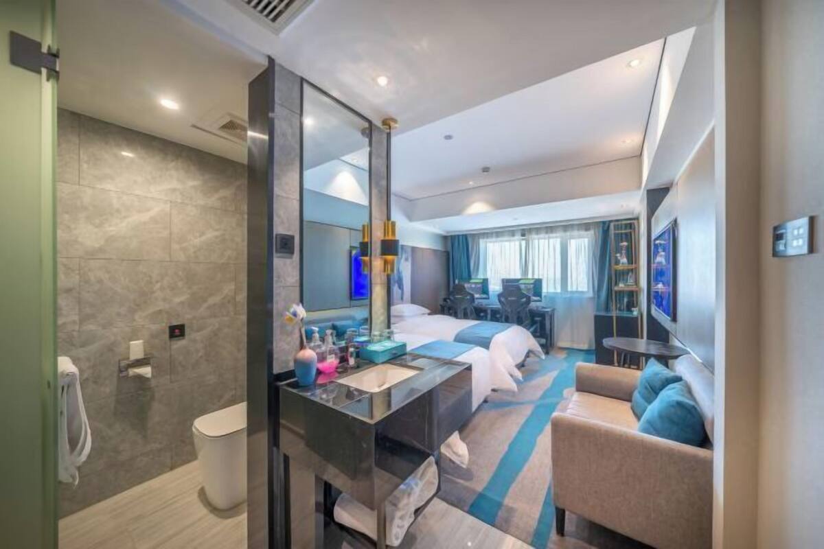 Una habitación de hotel moderna con baño, una zona de estar y una cama.