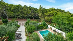 A pool surrounded by lush greenery and trees, with a patio area and outdoor seating. - Stunning home in Liznjan with private swimming pool, can be inside or outside (Liznjan)