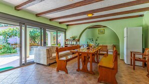 A dining area with a wooden table and chairs, a sofa, and a refrigerator. - Stunning home in Liznjan with private swimming pool, can be inside or outside (Liznjan)