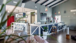 Une cuisine moderne avec un coin bar, des meubles blancs et une horloge au mur.