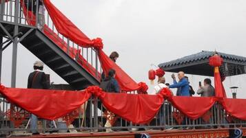 Una scala con tende rosse, una ringhiera in metallo e una piattaforma con persone.