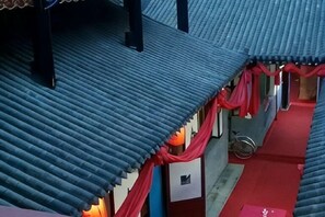 Un couloir avec un tapis rouge, un vélo et une rambarde en métal.
