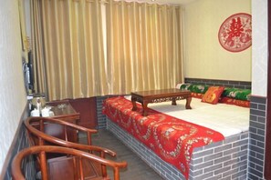 Una habitación de hotel con una cama, un escritorio de madera y una silla.