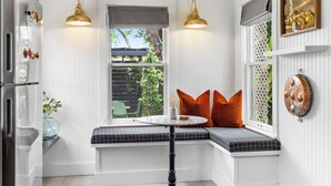 A corner seating area with a bench, a small table, and two wall-mounted lamps.