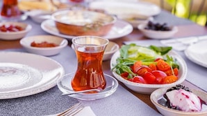 Una mesa dispuesta con platos, una taza de té y tazones de comida.
