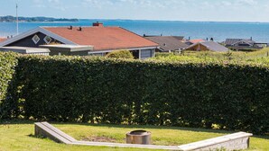Et boligområde med huse, en hæk og havudsigt.