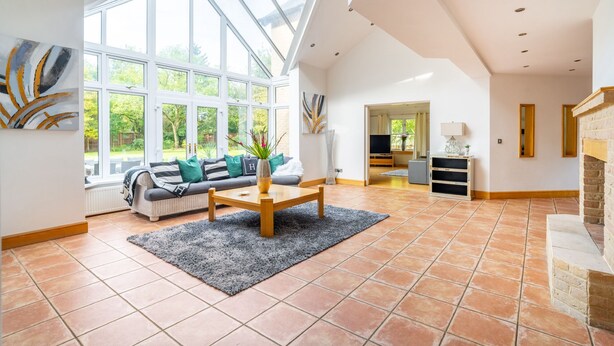 A spacious living room with a large window, a sofa set, a coffee table, and a fireplace. - Norwich Luxury Getaway With 4 Bedrooms & Annex (Norwich)