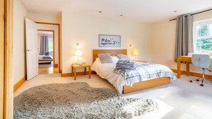 A bedroom with a bed, bedside lamps, a desk, and a chair. - Norwich Luxury Getaway With 4 Bedrooms & Annex (Norwich)