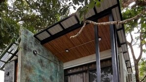 Loft moderno e compatto di lusso, con facciata in pietra, un piccolo spazio relax all'aperto e un tetto di paglia.